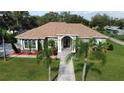 Single-story house with a light green exterior, brown roof, and palm trees at 2638 E Knights Griffin Rd Rd, Plant City, FL 33565