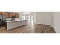 Bright, open kitchen with stainless steel appliances, a spacious island, and wood grain flooring at 6929 161St E Ter, Parrish, FL 34219
