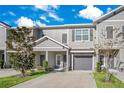 Two-story townhome, gray exterior, gray garage doors, and landscaping at 10962 Quickwater C, Riverview, FL 33569