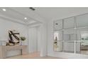 Bright foyer with light hardwood floors, a console table and large mirrors at 11449 Owasee Trails Pl, Riverview, FL 33569