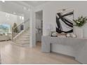 Light hardwood floors, contemporary console table, and open staircase at 11449 Owasee Trails Pl, Riverview, FL 33569
