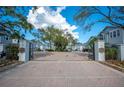 Gated community entrance with lush landscaping, brick paved road, and secure access at 2311 W Morrison Ave # 13, Tampa, FL 33629