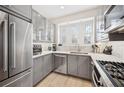 Well-lit kitchen featuring stainless steel appliances, granite countertops, and gray cabinetry with ample storage at 2311 W Morrison Ave # 13, Tampa, FL 33629