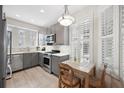 Cozy kitchen with stainless steel appliances, gray cabinets, and bright natural light from plantation shutters at 2311 W Morrison Ave # 13, Tampa, FL 33629