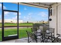 Relaxing screened-in patio featuring outdoor seating overlooking a grassy lawn and beautiful pond at 11658 Bluestone Ct, Parrish, FL 34219
