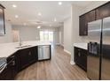 Modern kitchen with stainless steel appliances, dark cabinets and eat-in island at 6058 Barracuda Loop, Wimauma, FL 33598