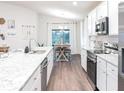 Modern kitchen featuring white cabinets, stainless steel appliances, and a dining area at 6949 161St E Ter, Parrish, FL 34219