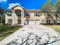 Charming two-story home with three-car garage, manicured front lawn, white fence and landscaping at 11175 Hyde St, Weeki Wachee, FL 34614