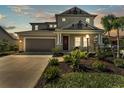 Charming two-story home with a well-manicured lawn and inviting front porch at dusk at 7048 White Willow Ct, Sarasota, FL 34243