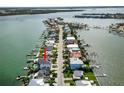 Aerial view of waterfront neighborhood with homes featuring private docks and the subject property marked with arrow at 820 Bay Point Dr, Madeira Beach, FL 33708