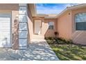 Close-up of the front entrance with freshly manicured garden beds, neutral toned stucco and decorative white trim at 1112 21St E St, Palmetto, FL 34221