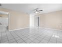 Spacious living room with pristine white tile floors, ceiling fan and neutral paint, flowing into other rooms at 1112 21St E St, Palmetto, FL 34221