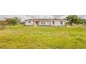 Expansive front lawn showcases a single-story home with brick accents, providing ample space and curb appeal at 10760 S County Road 39, Lithia, FL 33547