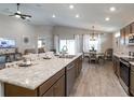 Bright open-concept kitchen with stainless steel appliances, light countertops, and ample cabinet space overlooking living areas at 7076 162Nd E Pl, Parrish, FL 34219