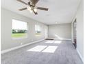 Airy living room featuring natural light, a ceiling fan, fresh paint, and plush new carpet flooring at 8630 Mary Ivy Dr, Plant City, FL 33567