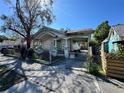 This neglected single-story home includes a fenced yard and covered parking at 921 E 12Th Ave, Tampa, FL 33605