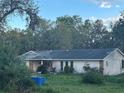 Exterior shot of home; pink with dark roof and surrounding greenery at 3133 Washington Rd, Valrico, FL 33594