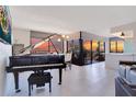Bright living room with a grand piano, modern lighting fixtures, and expansive windows offering sunset views at 6158 Palma Del Mar S Blvd # 604, St Petersburg, FL 33715