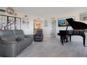 Inviting living room featuring a comfortable leather sofa, recliner, accent art, and a sleek grand piano at 6158 Palma Del Mar S Blvd # 604, St Petersburg, FL 33715