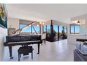 Bright living room with a grand piano, modern lighting fixtures, and expansive windows at 6158 Palma Del Mar S Blvd # 604, St Petersburg, FL 33715