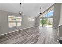 Sunlit living room boasts vaulted ceilings, hardwood flooring, and sliding glass doors with views of the lush backyard at 30816 Pumpkin Ridge Dr, Wesley Chapel, FL 33543