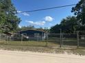 Fenced property with a well-maintained yard and a cozy home featuring durable siding at 37906 Tucker Rd, Zephyrhills, FL 33542