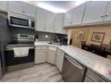 Modern kitchen features stainless steel appliances, gray cabinets, and white countertops at 3232 Lake Pine E Way # G1, Tarpon Springs, FL 34688