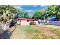 Expansive backyard showcasing lush green grass, mature trees, and a fenced perimeter for privacy at 4022 Watson Rd, Tampa, FL 33610