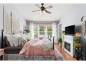 Cozy bedroom featuring a decorative headboard, fireplace, and a view to the outdoors at 2125 Wild Grape Pl, Riverview, FL 33578