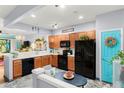 Well-lit kitchen with stainless steel appliances, a breakfast bar, and light wood cabinetry at 2125 Wild Grape Pl, Riverview, FL 33578
