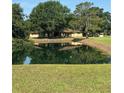 A serene pond reflecting the home surrounded by lush greenery creates a peaceful, nature-filled setting at 4101 N Forbes Rd, Plant City, FL 33565