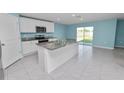 Modern kitchen with granite countertops, stainless steel appliances, and a spacious island at 8009 Sail Clover Ln, Zephyrhills, FL 33540