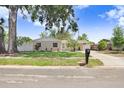 Charming single-story home featuring a well-manicured lawn, attractive landscaping, and brick facade at 1411 Fernwood Pl, Seffner, FL 33584