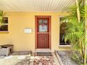 Close-up of the front door with a security screen and decorative tile walkway at 4921 Marlin Dr, New Port Richey, FL 34652