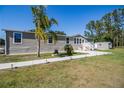 Attractive single-story home with neutral siding, palm tree, manicured lawn, charming front porch, and additional shed in backyard at 8318 Franklin Rd, Plant City, FL 33565