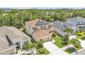 Aerial view of a two-story home with solar panels, manicured lawn, and mature trees at 9015 Spruce Creek Cir, Riverview, FL 33578