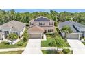 An aerial view of a two-story house with solar panels, landscaped yard, and driveway at 9015 Spruce Creek Cir, Riverview, FL 33578