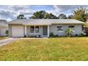 Lovely one-story home featuring a lush green lawn, neutral siding, and a welcoming entrance at 13032 Cumberland Dr, Largo, FL 33773
