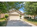 Inviting home featuring a driveway, well-kept lawn and trees that provide shade at 14385 Saltby Pl, Spring Hill, FL 34609