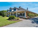 Beautiful home featuring a welcoming front porch with rocking chairs and manicured landscaping at 701 E 60 Hwy, Plant City, FL 33567