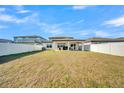 Spacious backyard featuring a covered patio, lush green grass, and a privacy fence at 1009 Golden Shiner Ave, Ruskin, FL 33570