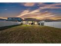 Spacious backyard featuring a covered patio, lush green grass, and a privacy fence at 1009 Golden Shiner Ave, Ruskin, FL 33570