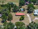 Aerial view of house with red metal roof, trees, and long driveway at 18818 Dorman Rd, Lithia, FL 33547
