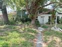 Charming single-story home featuring a mature tree-lined front yard and a covered front porch entry at 2415 Goldenrod St, Sarasota, FL 34239