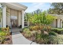 Inviting front entrance with a double door, columns, and lush landscaping at 6007 Hammock Hill Ave, Lithia, FL 33547