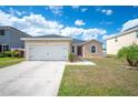 This home features a two-car garage, landscaped yard, and neutral exterior paint at 3425 San Moise Pl, Plant City, FL 33567
