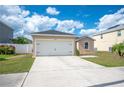 A clean two-car garage with lawn and landscaping in a modern residential home at 3425 San Moise Pl, Plant City, FL 33567