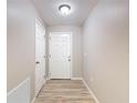 Hallway with wood floors, neutral paint, and white doors at 12043 Centralia Rd, Weeki Wachee, FL 34614