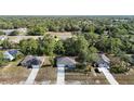 Aerial view showing a single-story home in a community with neighboring houses and a lush, green landscape at 12053 Centralia Rd, Weeki Wachee, FL 34614
