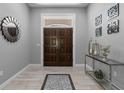 Elegant foyer with wood-look tile floors, modern decor, and a double-door entry at 7313 Crape Myrtle Way, Sarasota, FL 34241
